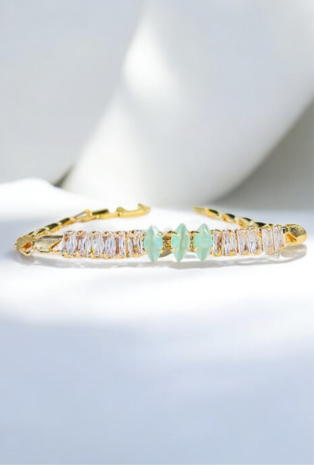 “Elegant Gold Bracelet with Crystal and Green Gem Accents”