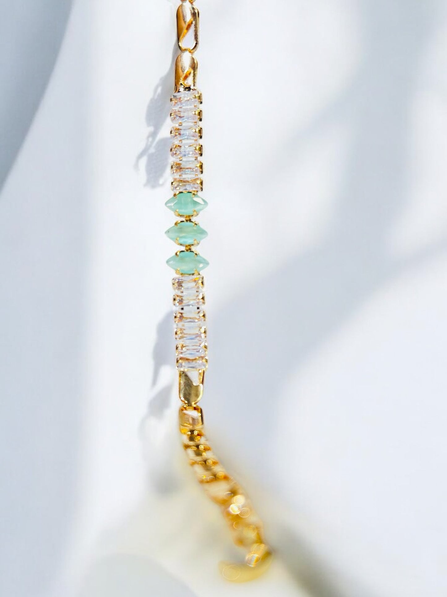 “Elegant Gold Bracelet with Crystal and Green Gem Accents”